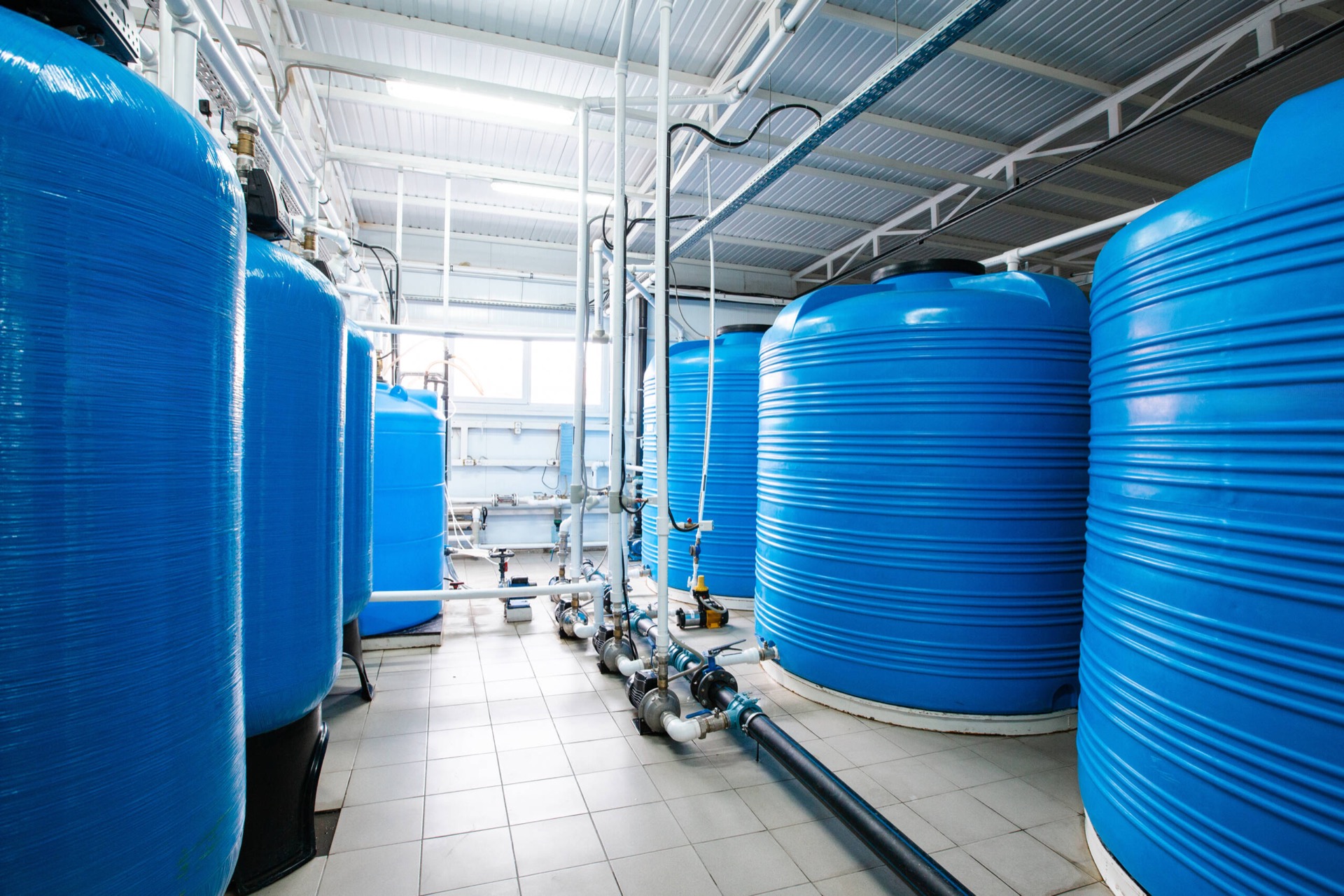 Industrial water treatment tanks, piping and pumps in a Plastco facility