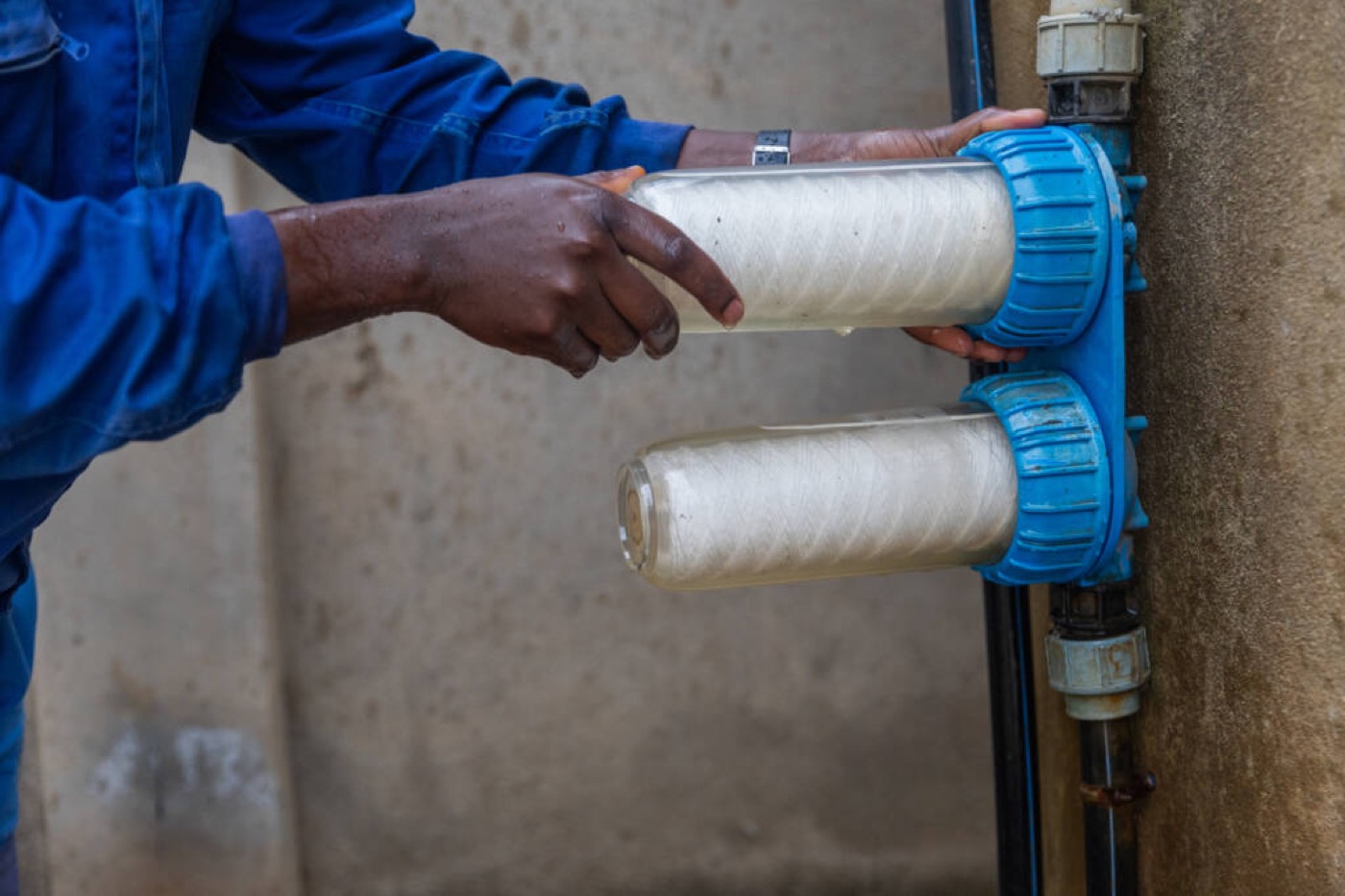 Technician fitting wound cartridge filters in blue housings