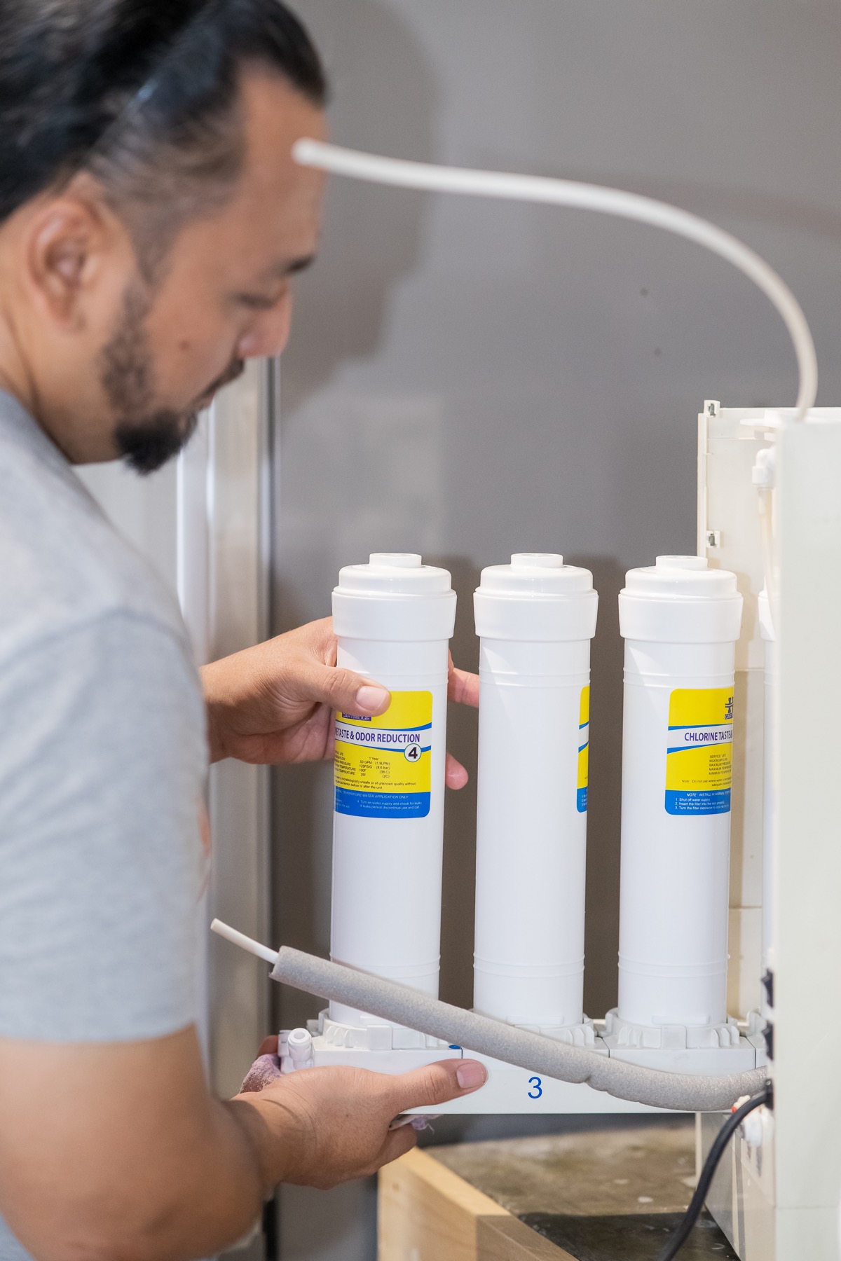 Technician servicing a multi-stage water filtration unit